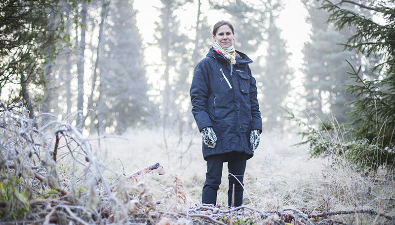 Bild på Johanna Sandahl som står ute i naturen